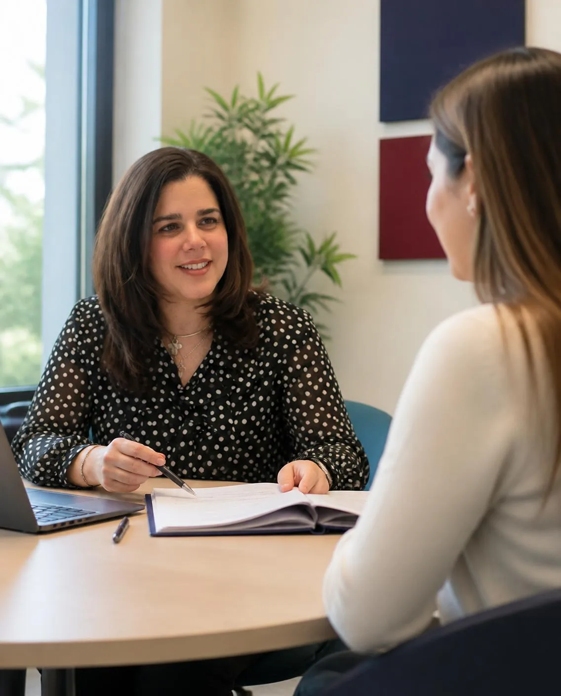 Malinalli Cortés González, gestora administrativa, revisando un expediente con una clienta